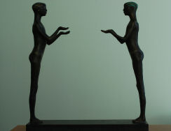 Skulptur av to figurer med utstrakte hender.