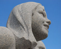 Skulptur fra Vigelandsparken av ansikt til ung jente med skaut.