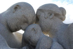 Skulptur fra Vigelandsparken av mor, far og barn som har hodene mot hverandre.