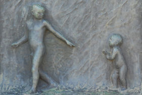 Relieff fra Vigelandsparken av to barn som ser på hverandre hvor den ene rekker ut hånden.