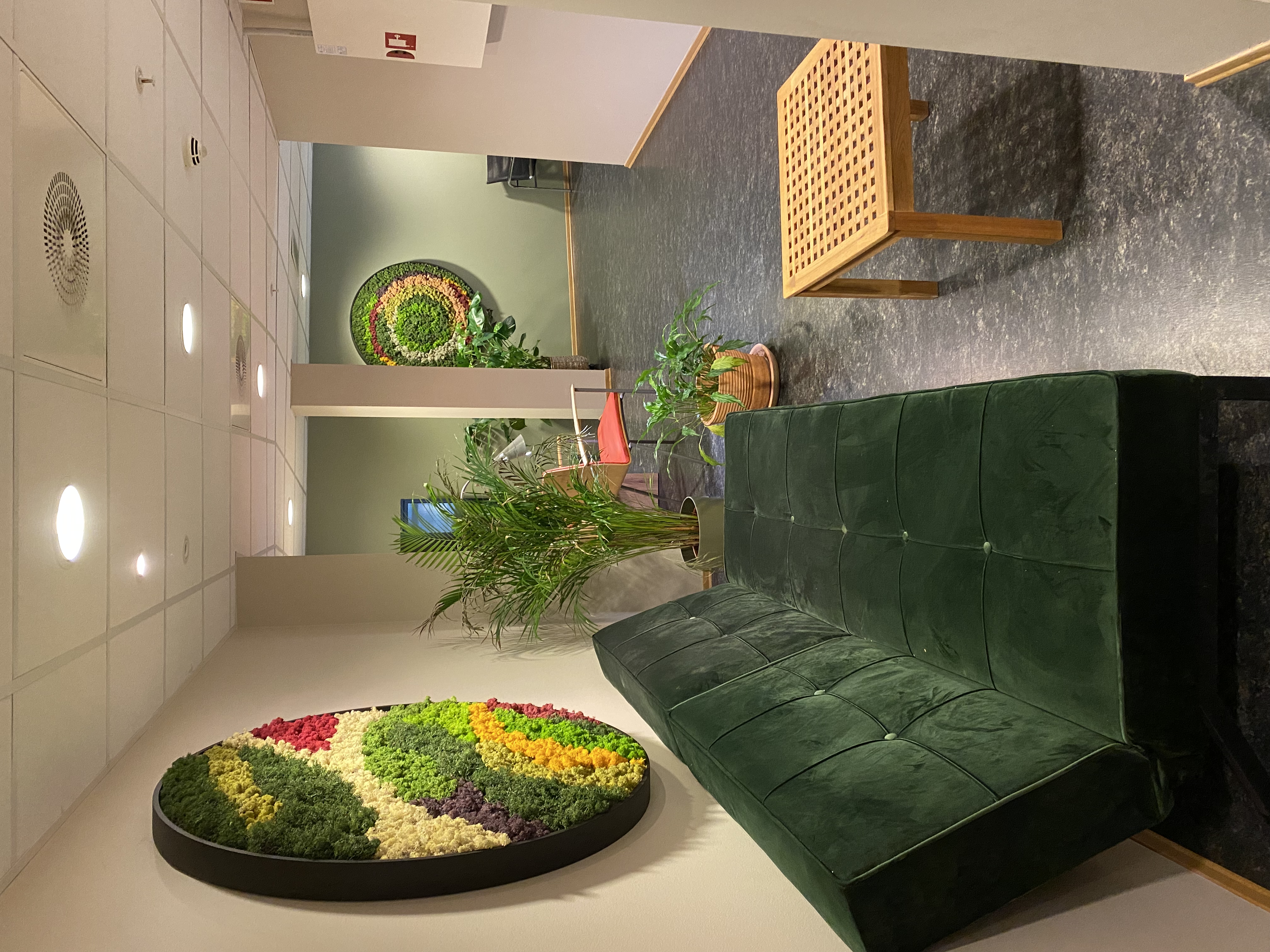 Foto av venterom med grønn sofa.